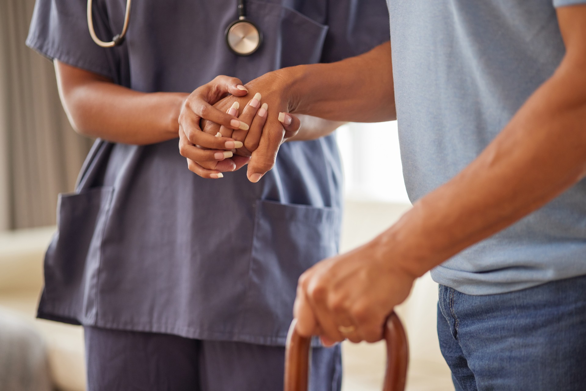 Retirement, healthcare and support with a nurse and senior patient in an old age home with a walking stick. Elderly man and medical professional walking and holding hands in trust, care and help